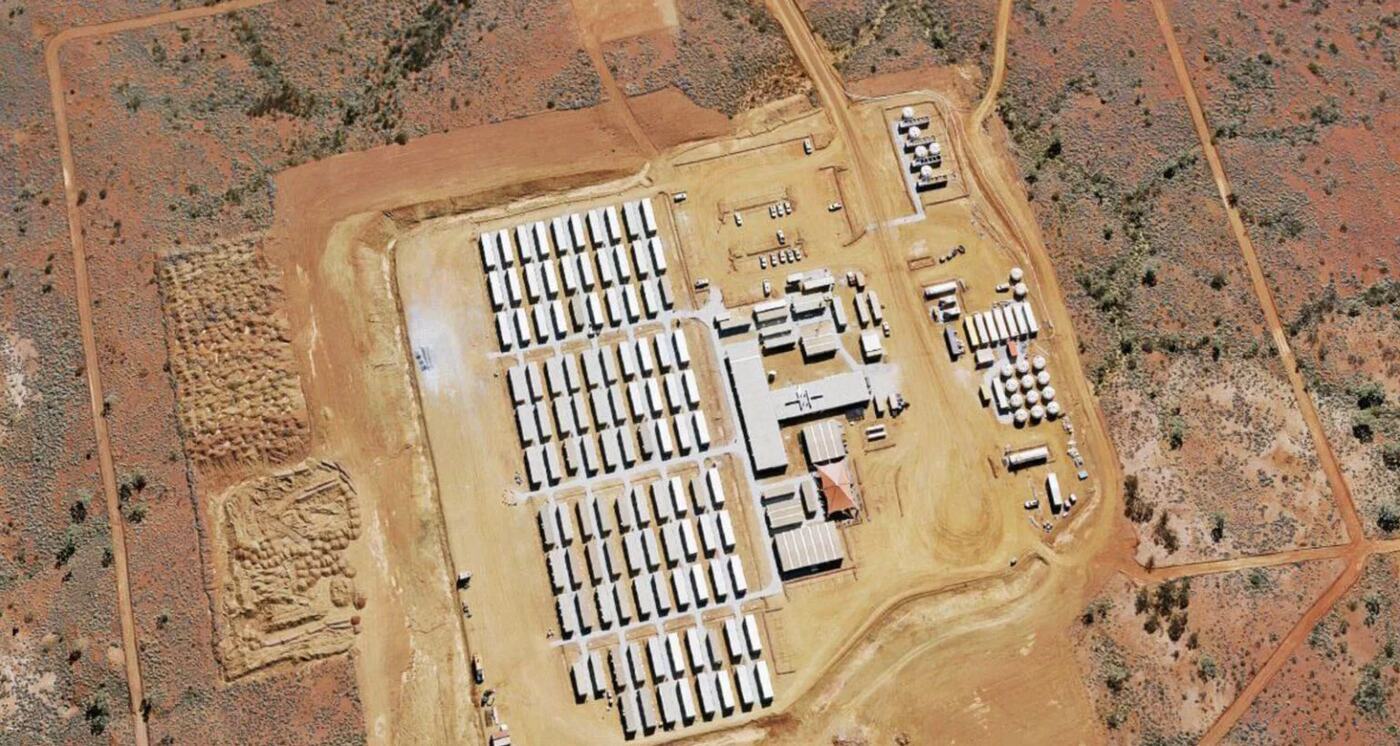 Overhead aerial of a remote accommodation camp with rows of dongas and central amenities