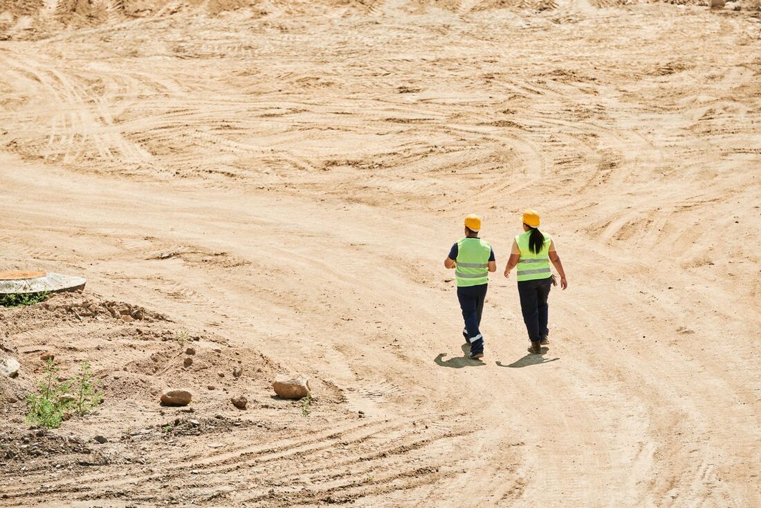 Engineers in high-visibility gear walking across a remote construction site